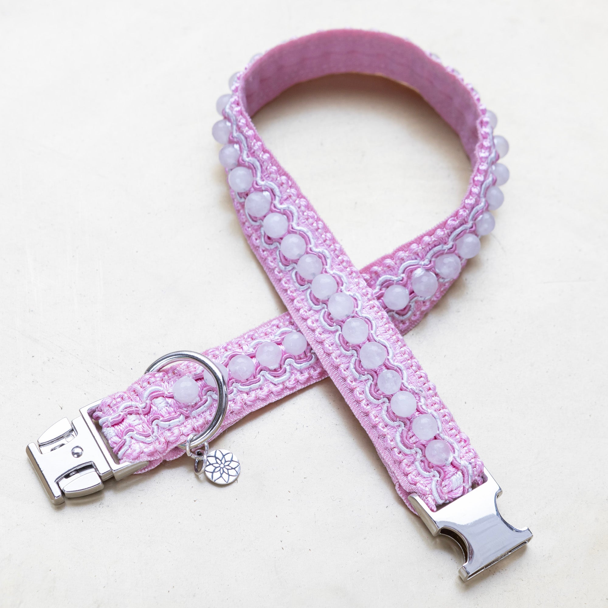 Ruusukvartsi korupanta pinkillä koristenauhalla